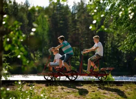 Tre gutter på en dresinsykkel ved vannet i Vansbro