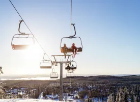 Børn sidder i en skilift.