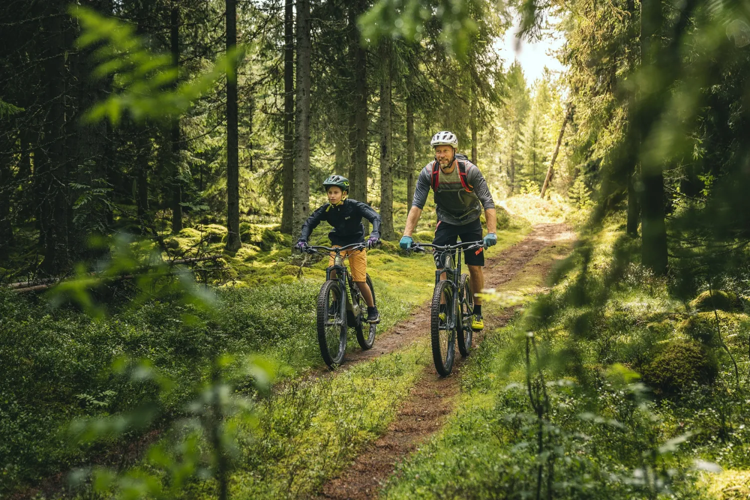 Een man en jongen mountainbiken over een karrespoor.