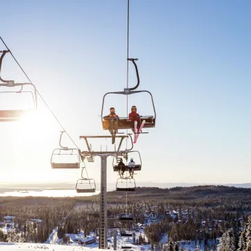 Børn sidder i en skilift.